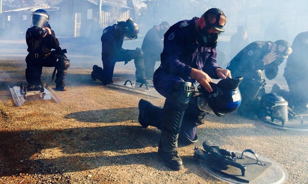 ME politie doen gasmaskers en helmen op