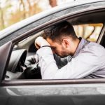 Man leunt op het stuur van de auto na ongeluk