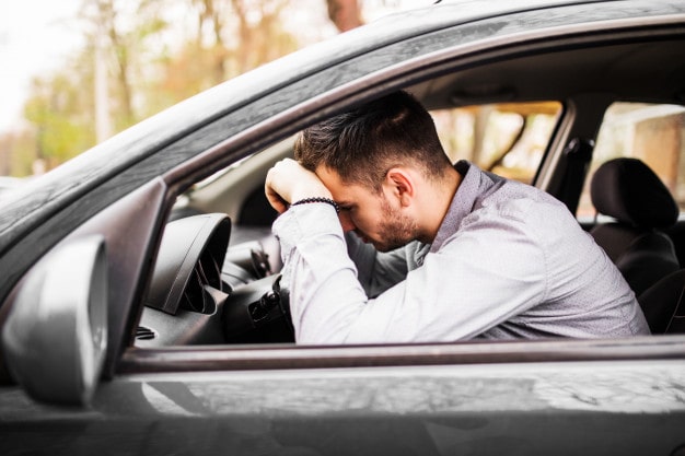 Man leunt op het stuur van de auto na ongeluk